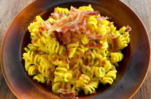 A plate of fresh Fusilli according to the recipe with Gorgonzola, Saffron and Speck sauce from Rawpasta Ljubljana